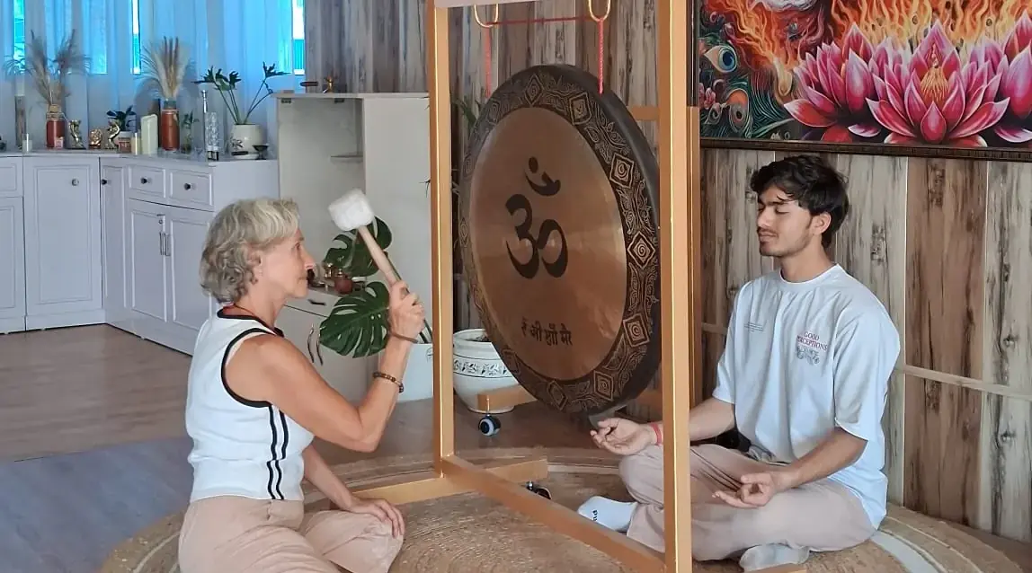 Christel jouant du gong pendant une séance de yoga du son