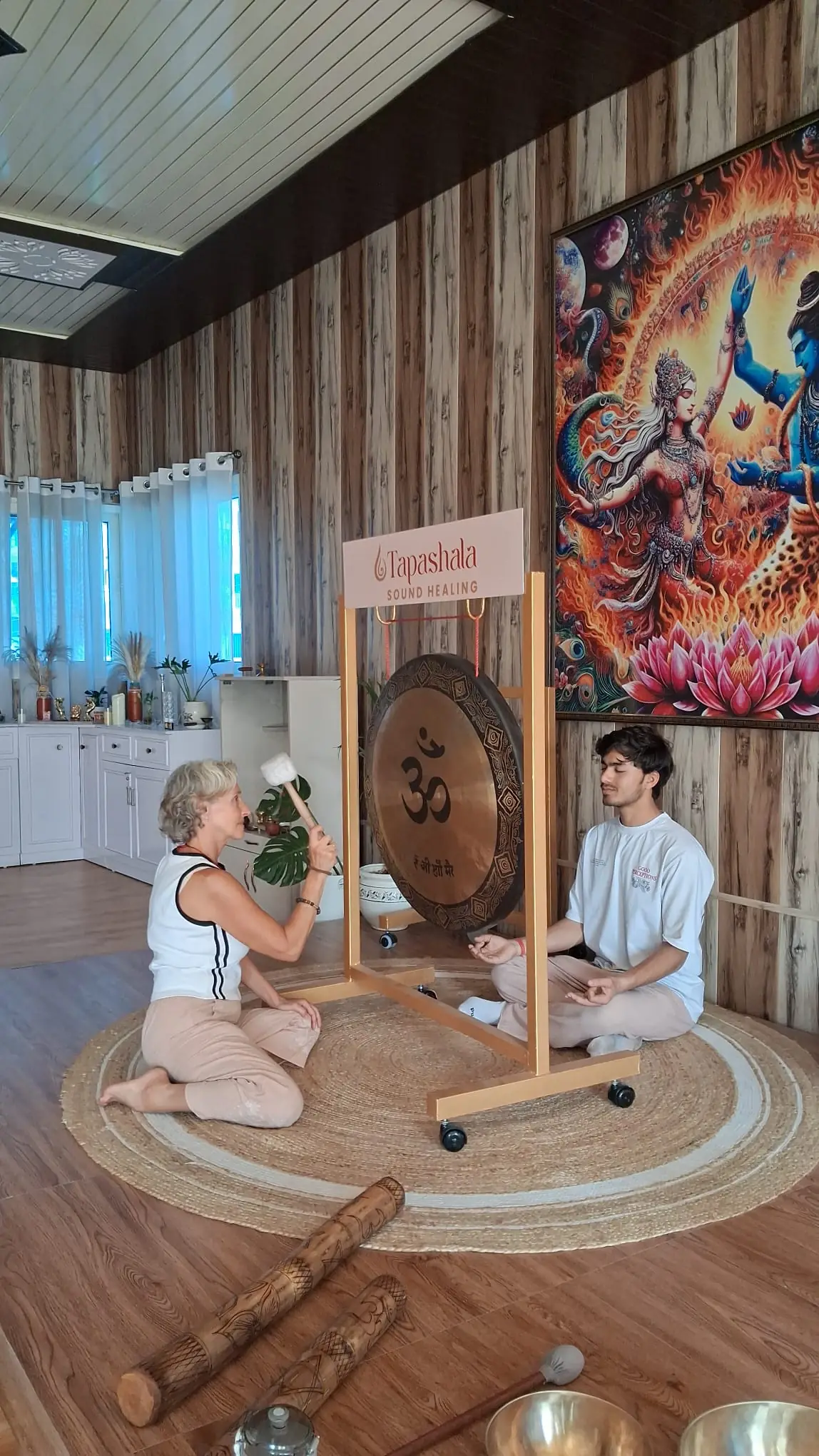 Christel jouant du gong pendant une séance de yoga du son