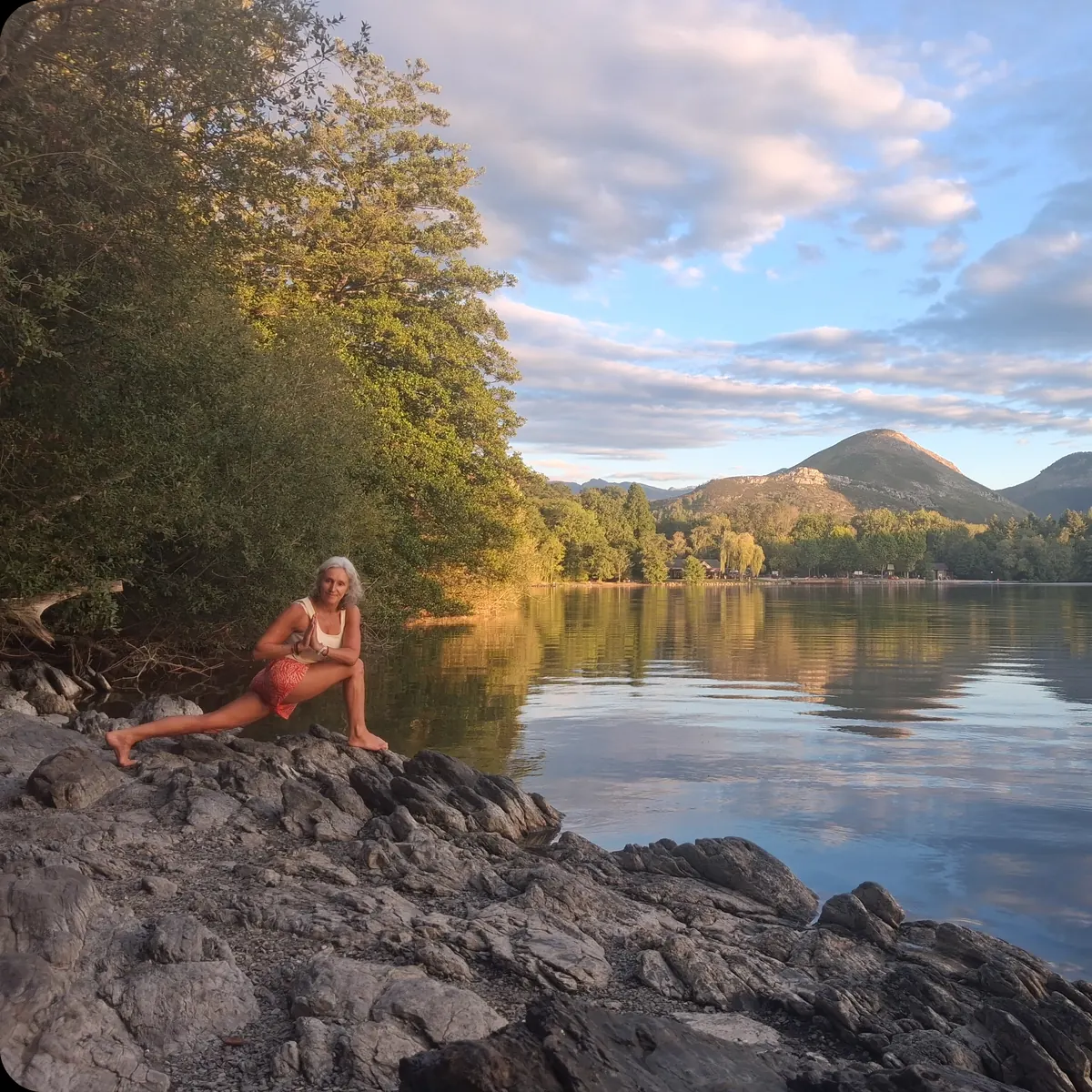 Fente basse, mains jointes, au bord d’un lac de montagne